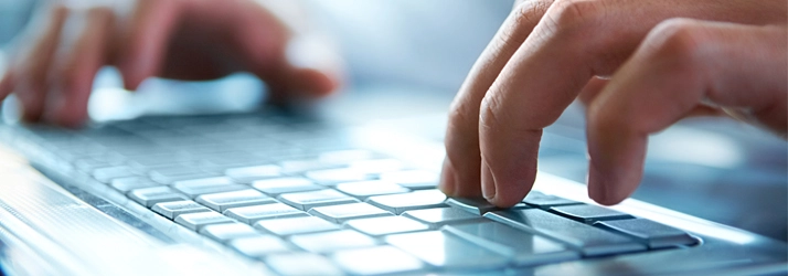 Hands typing on a keyboard.